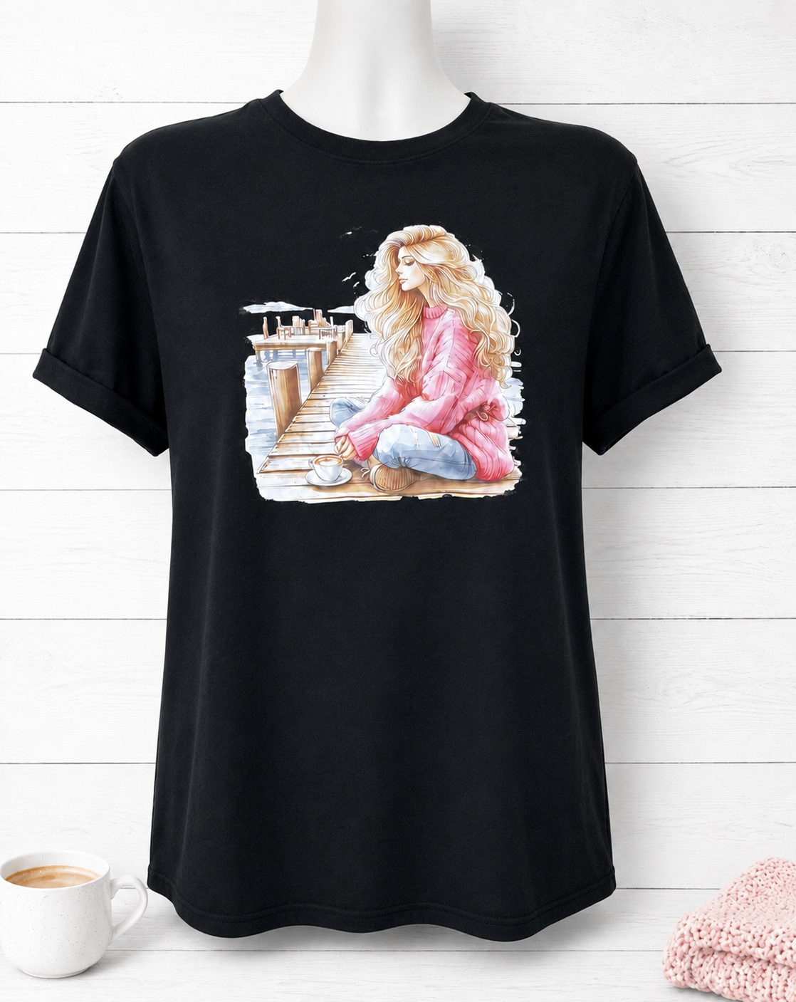 Custom Graphic T-Shirt- featuring a design of a girl in a pink sweater on a pier, deep in thought while drinking a cup of coffee.